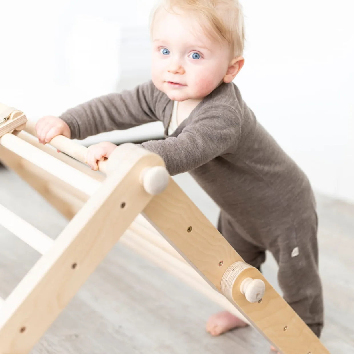 Bébé escaladant un triangle Pikler en bois Montessori — structure de motricité cadeau baptême | Tinitto